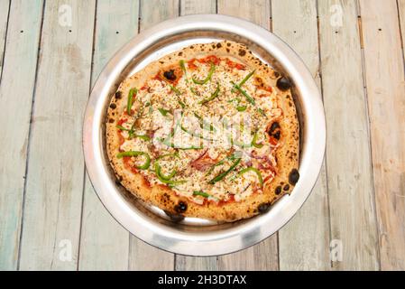 Pizza di pollo con peperoni e cipolla rossa con un sacco di mozzarella su un piatto di acciaio Foto Stock