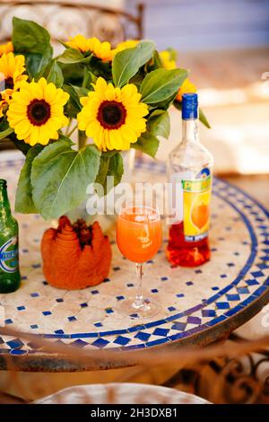 Cocktail Aperol Spritz su un tavolo con girasoli in un ristorante di pizza francese Foto Stock