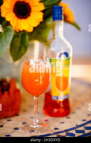 Cocktail Aperol Spritz su un tavolo con girasoli in un ristorante di pizza francese Foto Stock