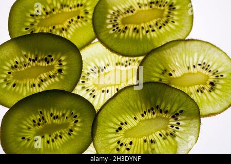 Frutta kiwi, uva spina cinese (Actinidia deliciosa), fette di kiwi in controluce, ritaglio Foto Stock