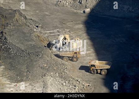 I camion di scarico sono caricati con un retroescavatore nel Pit aperto di Fimiston, Australia, Australia occidentale, Kalgoorlie Foto Stock