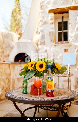 Cocktail Aperol Spritz su un tavolo con girasoli in un ristorante di pizza francese Foto Stock