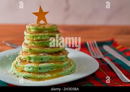 Frittelle a forma di albero di Natale sul tavolo. Colazione di Natale Foto Stock