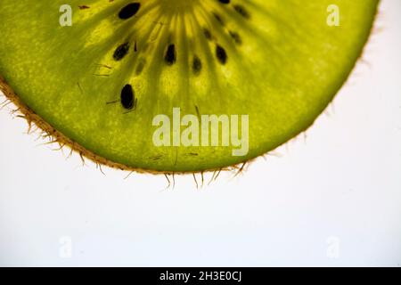 kiwi Fruit, uva spina cinese (Actinidia deliciosa), kiwi slice in controluce, ritaglio Foto Stock