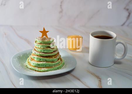 Frittelle a forma di albero di Natale sul tavolo. Colazione di Natale Foto Stock