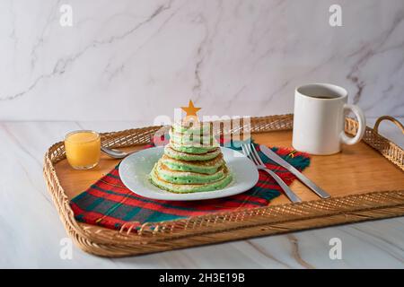 Frittelle a forma di albero di Natale sul tavolo. Colazione di Natale Foto Stock