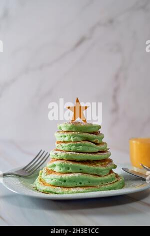 Frittelle a forma di albero di Natale sul tavolo. Colazione di Natale Foto Stock