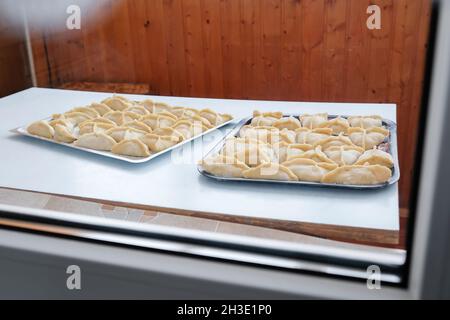 Sul tavolo giacciono i manti grezzi triangolari. Preparazione della cottura Foto Stock