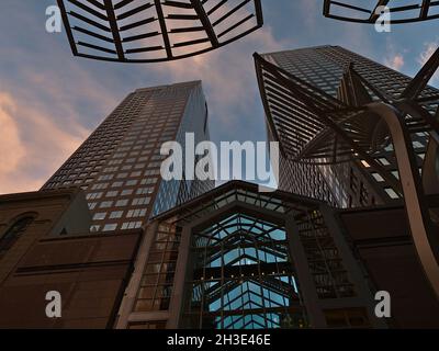 Vista ad angolo basso degli alberi della Galleria su Stephen Avenue nel centro di Calgary, con grattacieli Eighth Avenue Place e un cielo spettacolare. Foto Stock