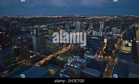 Splendida vista ad alto angolo del centro di Calgary sud-orientale con edifici illuminati e alti e Stampede con arena coperta Scotiabank Saddledome. Foto Stock