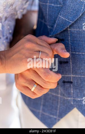 Crop faceless coppia sposata in abiti da matrimonio tenendo le mani con anelli di nozze in luce diurna Foto Stock