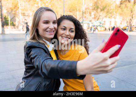 Buone giovani amici multietnici sorridenti e sorridenti per strada Foto Stock