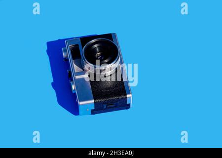 Da sopra fotocamera vintage su sfondo blu chiaro Foto Stock