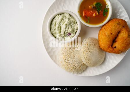 Idli vada sambar chutney isolato su bianco - South Indian colazione vegetariana thali vista dall'alto Foto Stock