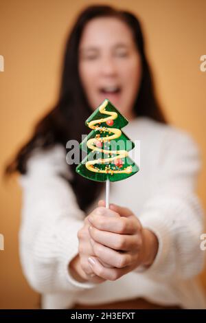 Natale tratta lollipop verde su un bastone in forma di abete. Foto Stock