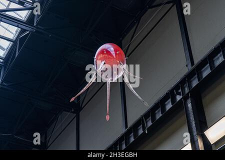 TATE MODERN LONDON, REGNO UNITO. 28 Ott 2021. Anicka Yi 'in Love with the World' è una mostra all'interno della moderna sala turbina Tate con macchine galleggianti chiamate aerobi con la forma di veicoli aerei senza equipaggio (UAV) basati su forme di vita oceanica e funghi che seguono un percorso di volo unico generato da una vasta gamma di opzioni in il loro software. I comportamenti individuali e di gruppo degli aerobi si sviluppano nel tempo, influenzati dall’ecosistema, comprese le firme termiche delle persone nelle vicinanze. La mostra si svolge dal 15 ottobre al 16 gennaio 2022. amer Ghazzal/Alamy Live News Foto Stock