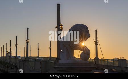 Sant'Agostino, Florida, USA - 26 ottobre 2021 - il sole che sorge sta sbucciando sopra la zampa della statua del leone al Ponte dei leoni di Sant'Agostino. Foto Stock