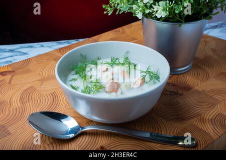 Helsinki / Finlandia - 28 OTTOBRE 2021: Cucina tradizionale finlandese: Ciotola di cremosa zuppa di salmone con aggiunta di aneto. Foto Stock