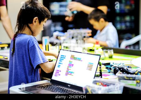 Gruppo di bambini che frequentano la classe di robotica Lego e che costruiscono e testano il robot model.Children ISTRUZIONE STEM ed esperimenti scientifici creativi divertimento. Foto Stock