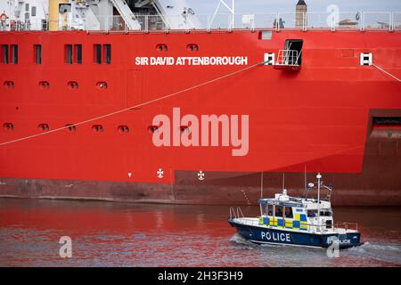 Un lancio della polizia fluviale si affianca alla nuova nave di ricerca polare della British Antartic Survey, l'RRS Sir David Attenborough, ormeggiata sul Tamigi al prime Meridian di Greenwich, durante il suo breve soggiorno in mostra al pubblico, durante la conferenza COP26 sul cambiamento climatico a Glasgow, Il 28 ottobre 2021, a Londra, Inghilterra. Il Attenborough da 200 milioni di sterline è un rompighiaccio Polar di classe 4 con attrezzature di ricerca all'avanguardia, un elipad, gru, laboratori a bordo e altre apparecchiature per la rilevazione e il campionamento dell'oceano. Foto Stock