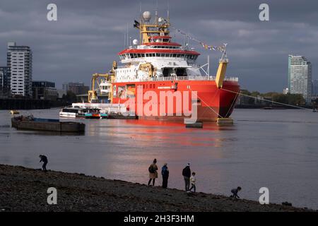 Londoners si trova sulla riva del Tamigi e ammira la nuova nave di ricerca polare del British Antartic Survey, il RRS Sir David Attenborough, ormeggiato sul Tamigi al prime Meridian di Greenwich, durante il suo breve soggiorno in mostra al pubblico, durante la conferenza COP26 sul cambiamento climatico a Glasgow, Il 28 ottobre 2021, a Londra, Inghilterra. Il Attenborough da 200 milioni di sterline è un rompighiaccio Polar di classe 4 con attrezzature di ricerca all'avanguardia, un elipad, gru, laboratori a bordo e altre apparecchiature per la rilevazione e il campionamento dell'oceano. Foto Stock