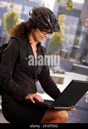 Donna d'affari che indossa casco per bicicletta Foto Stock