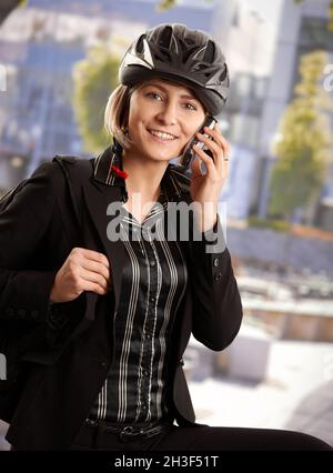 Donna d'affari in casco per bicicletta Foto Stock
