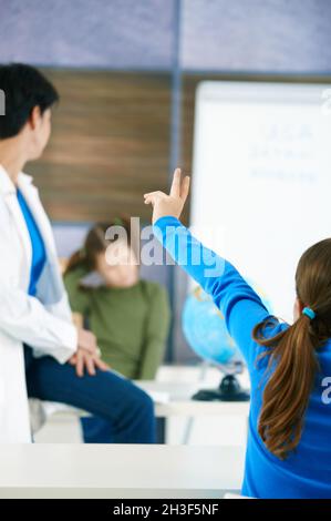 Studentessa alzando la mano Foto Stock