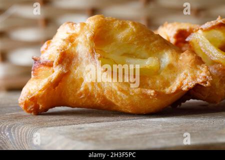 Ciambelle fresche fatte in casa la cui forma è diversa ogni volta a causa dei diversi pezzi di mela nascosti in loro. Foto Stock