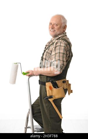 Uomo anziano che dipinge a casa Foto Stock