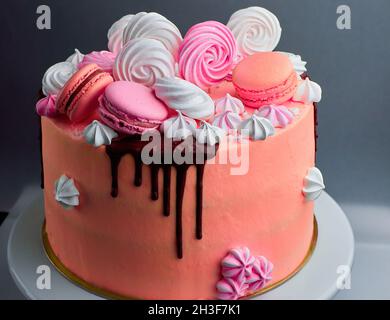 Gustosa torta rosa decorata con macaron e cioccolato Foto Stock