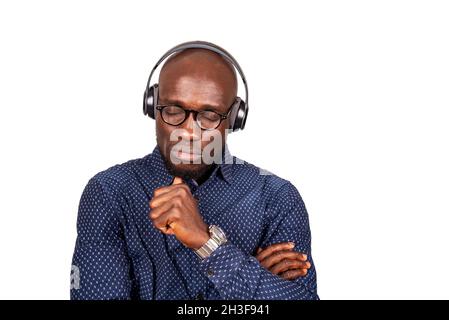 bel giovane uomo che indossa occhiali che si divertono ad ascoltare la musica nelle sue cuffie con gli occhi chiusi Foto Stock