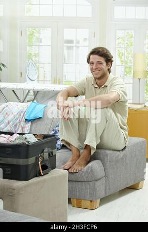 Imballaggio giovane uomo per le vacanze Foto Stock