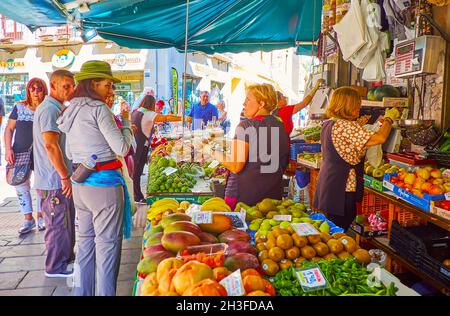 GRANADA, SPAGNA - 27 SETTEMBRE 2019: La coda al mercato dei prodotti all'angolo di Plaza Pescaderia piazza; la gente sceglie frutta fresca e ve Foto Stock