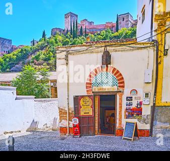 GRANADA, SPAGNA - 27 SETTEMBRE 2019: La facciata di Teteria El Banuelo Teahouse con arco a ferro di cavallo in stile arabo e l'Alhambra medievale in backgroun Foto Stock