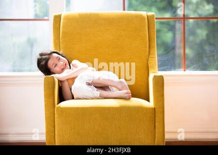 Bella ragazza sdraiata sul divano Foto Stock