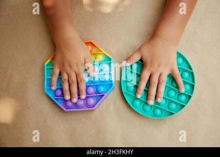 Giocattolo trendy in silicone colorato arcobaleno antistress pop it per il  bambino. Vista dall'alto Foto stock - Alamy