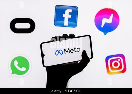 Facebook cambia il suo nome in Meta. Smartphone con logo Meta sullo sfondo su loghi di prodotti di proprietà della metaverse di facebook. Foto Stock