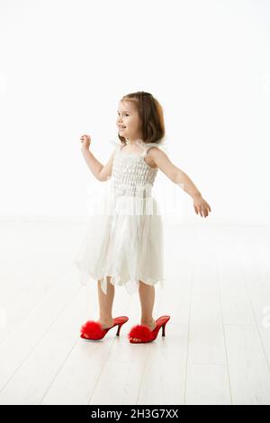 Bambina che cerca scarpe mamme Foto Stock