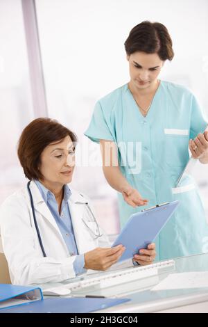 Medico e assistente che discutono di lavoro Foto Stock