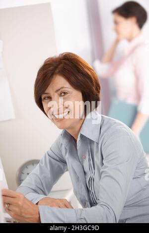 Sorridente lavoratrice matura Foto Stock