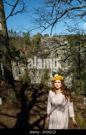 Una ragazza in un abito rosa e cappello sullo sfondo di montagne e gole in Sassonia svizzera, Germania, Bastei. Foto Stock