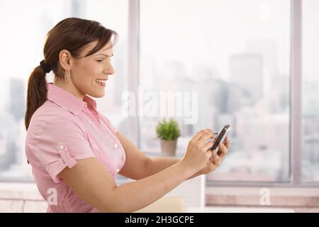 Imprenditrice utilizza lo smartphone Foto Stock