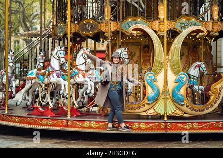 Una ragazza in un cappotto sul carosello della città in Avignon.France. Foto Stock