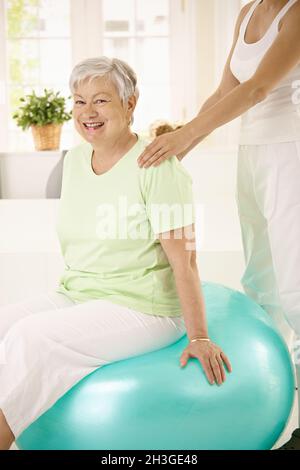 Personal trainer che assiste la donna anziana Foto Stock