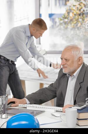 Uomo d'affari che lavora con un collega in background Foto Stock