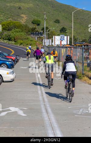 SAN FRANCISCO, STATI UNITI D'AMERICA - Apr 18, 2021: Una vista posteriore dei giovani ciclisti che cavalcano sul Golden Gate Bridge a San Francisco in una giornata di sole Foto Stock