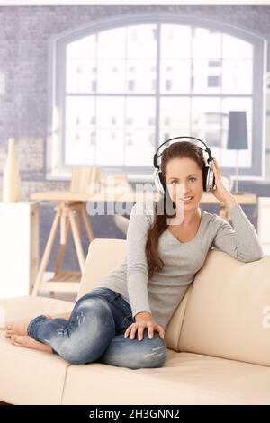 Giovane donna godendo la musica attraverso le cuffie Foto Stock