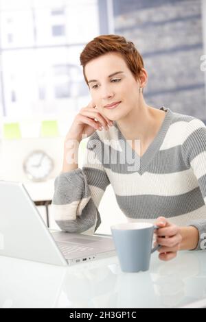 Giovane donna lettura sul computer portatile Foto Stock