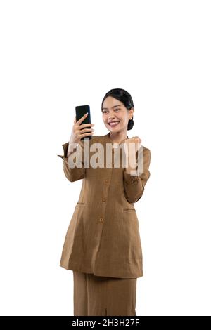 donna in uniforme eccitato mentre guarda il suo telefono Foto Stock